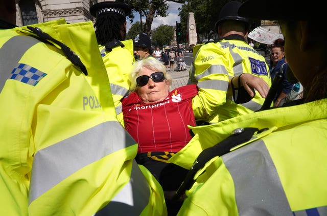 A demonstrator is carried away by police during a protest by members of Extinction Rebellion on Whitehall 