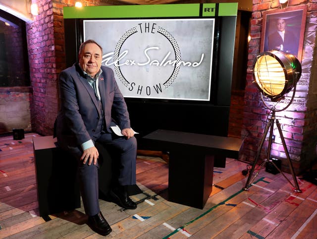 Alex Salmond appearing in front of a backdrop for his show 