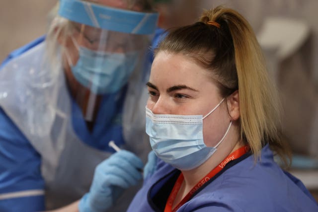 A staff member at the home receives her first dose of the vaccine