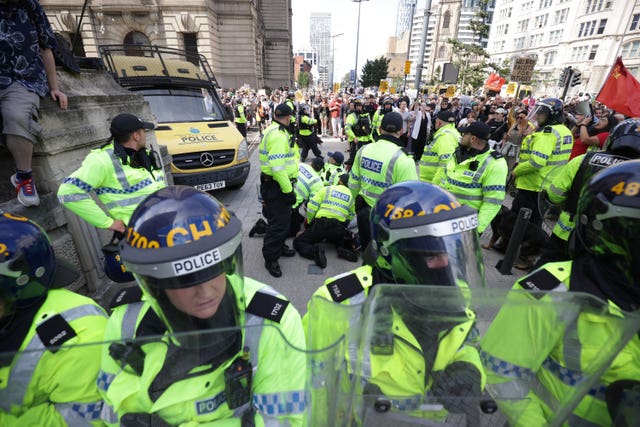 Police restrain a man during a protest in Liverpool