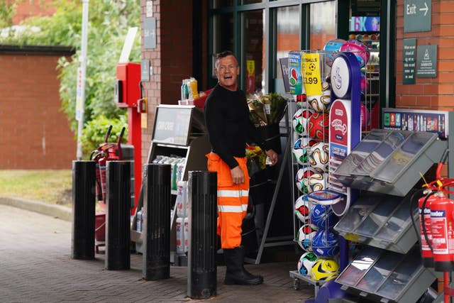 A man shouting as he enters a fuel station shop