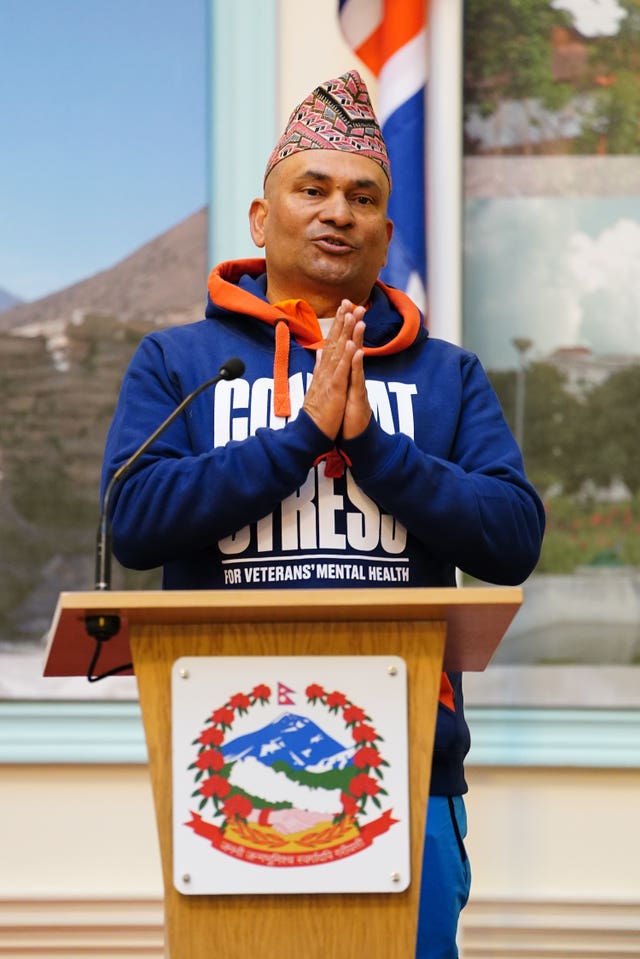 Sujan Katuwal behind a lectern wearing a Combat Stress hoodie