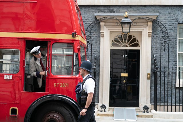 A red bus parked outside 10 Downing Street, London