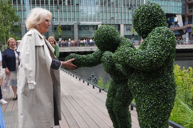 Camilla meets two people dressed as bushes