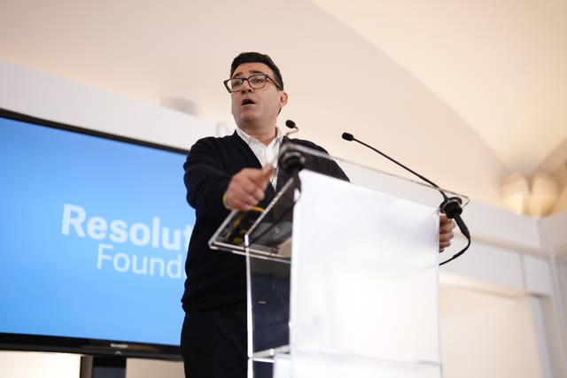 Andy Burnham speaking from behind a lectern