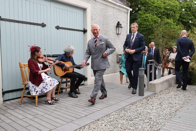 Charles walks past some musicians
