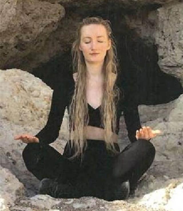 Rosie Fender in a yoga pose next to rocks