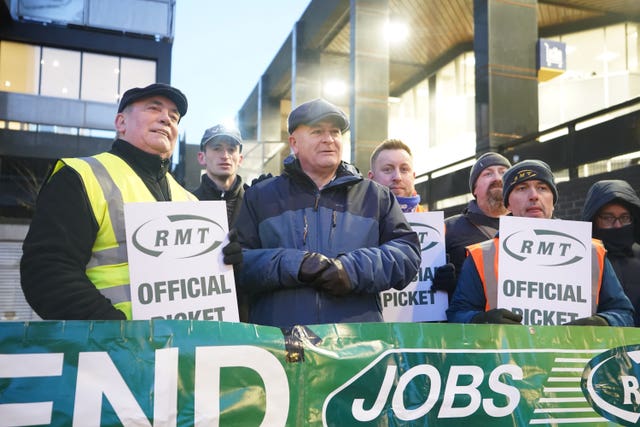Mick Lynch (centre) general secretary of the Rail, Maritime and Transport union (RMT) joins members on the picket line outside London Euston train station during a strike in a long-running dispute over jobs and pensions