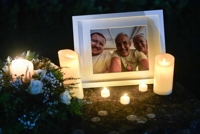 Candles burn next to a photo during a vigil in Louth for Mark and Louise O’Connor and their son Evan
