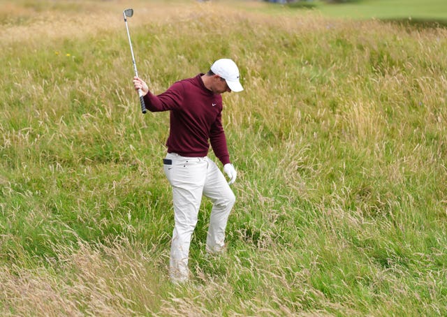 Rory McIlroy looks down at the thick rough