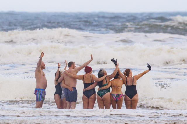 People take part in a New Year’s Day Dip at Castlerock Beach in Coleraine 