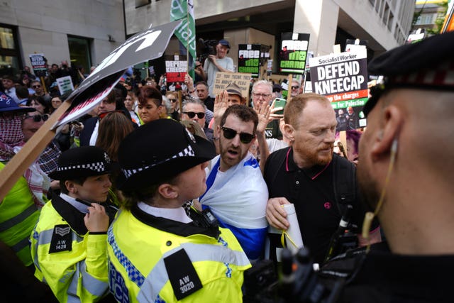 Police officers removing a counter-protester (centre, wearing flag of Israel and black top) in the middle of the supporters of Kneecap’s Liam Og O Hannaidh