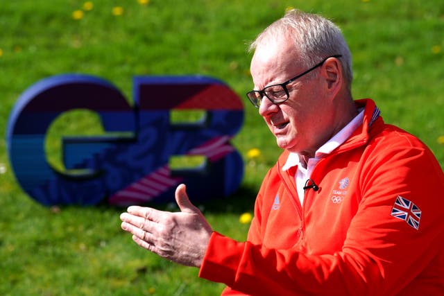 Mark England talks in front of a GB sign on the grass