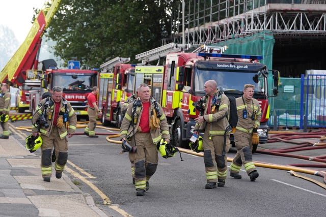 Firefighters walk along a road