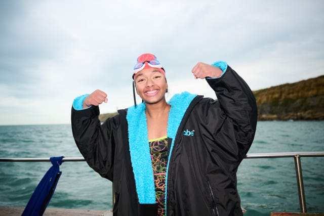 Prisha Tapre in swimming hat and goggles gestures while on a boat