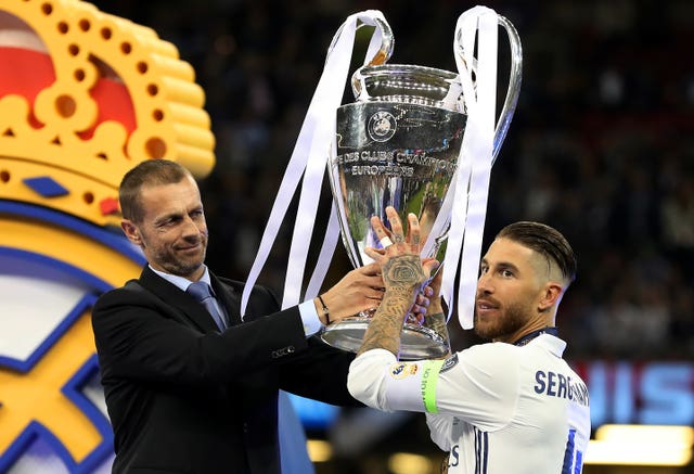 UEFA president Aleksander Ceferin hands the Champions League trophy to Real Madrid captain Sergio Ramos