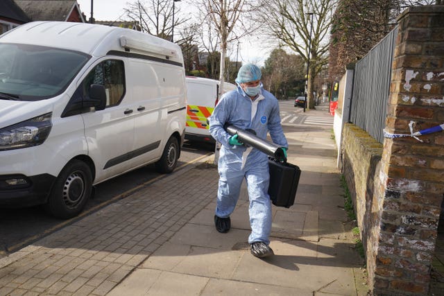 A forensic officer outside a property on Castlebar Road, Ealing, west London, where a woman in her 40s was found dead on Monday