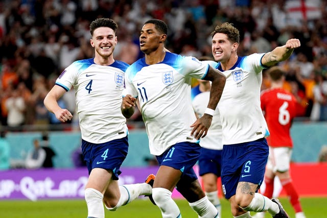 England’s Marcus Rashford, centre, celebrates scoring the opening goal against Wales