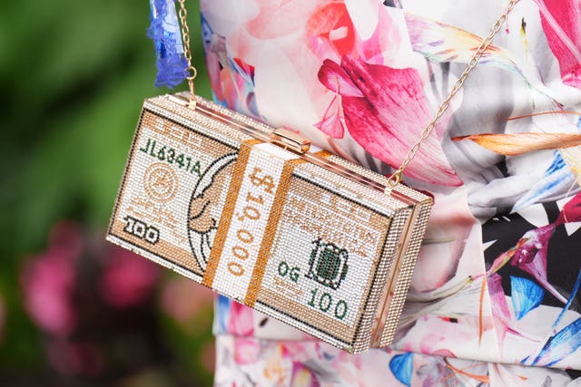 A woman sports a bag with a 10,000 dollar bill design