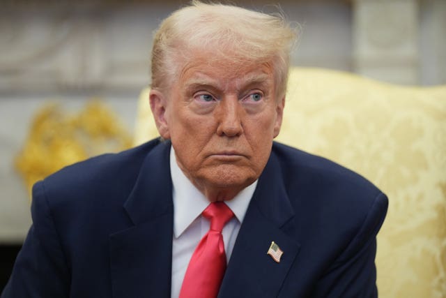 US President Donald Trump looks at the camera