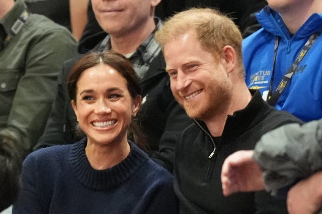 Meghan and Harry smile as they watch competitors in the Invictus Games 