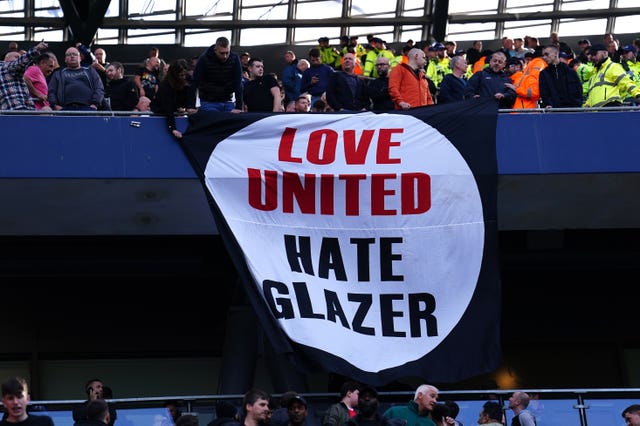 Fans hold up a Love United Hate Glazer banner