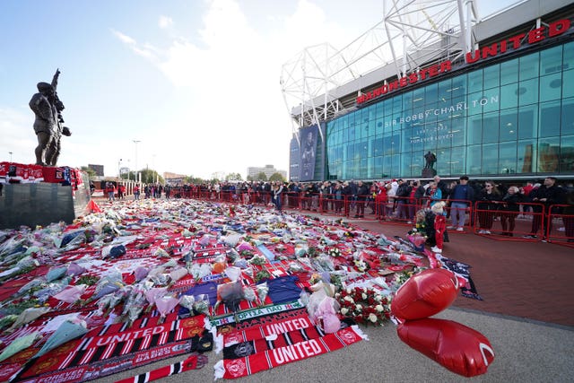 Tributes to Sir Bobby Charlton have been left outside the 'United Trinity' statue