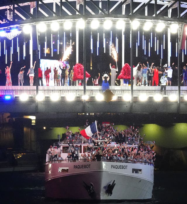 The French team head under a bridge filled with performers 