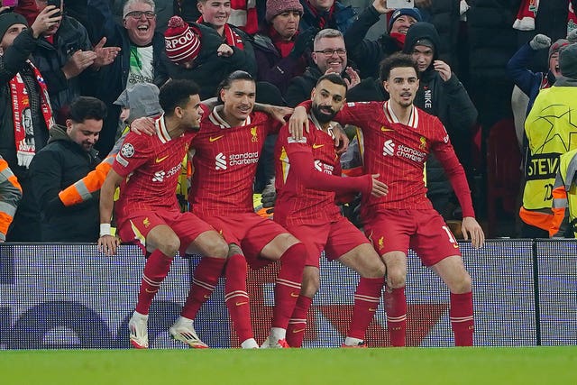 Mohamed Salah, centre right, sits on an advertising hoarding with team-mates to celebrate his goal against Lille