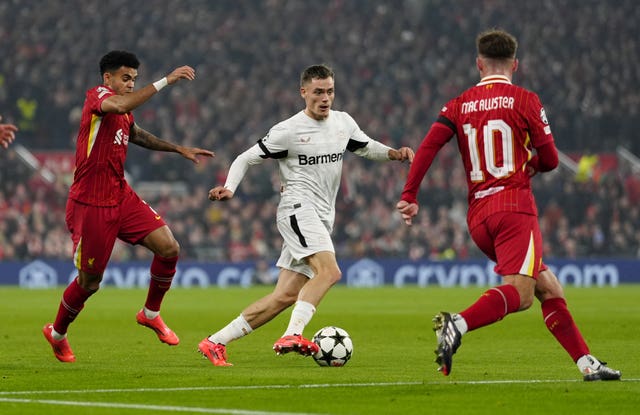 Bayer Leverkusen's Florian Wirtz dribbles past Liverpool's Luis Diaz and Alexis Mac Allister 