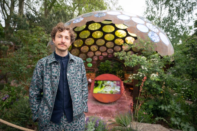 Tom Massey in front of a garden sculpture