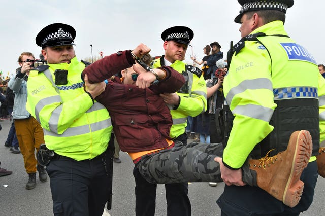 A demonstrator is carried away by police