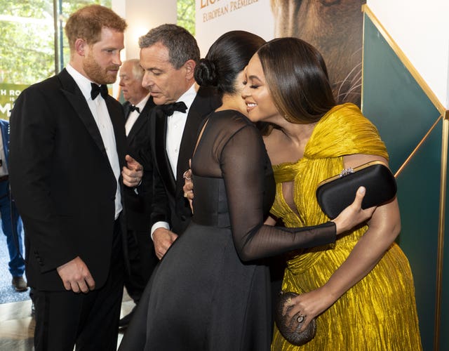 Harry chats to the then Disney boss Bob Iger as wife Meghan embraces Beyonce at the European Premiere of Disney’s The Lion King at the Odeon Leicester Square last summer. Niklas Halle’n/PA Wire