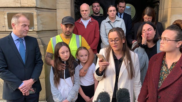 Tia Skelton, centre, the sister of Lewis Skelton, is surrounded by members of their family and solicitor Neil Hudgell, left, as she reads a statement to the media outside Hull Coroner's Court