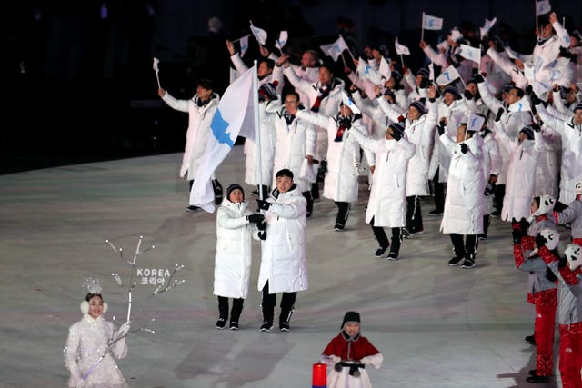 Chung Gum Wang and Yunjong Won lead out North Korean and South Korean athletes 