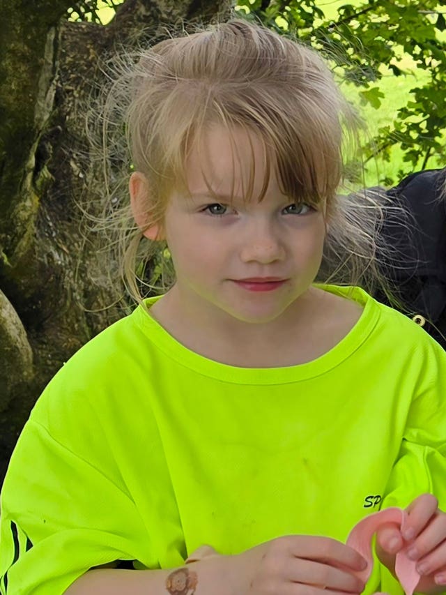 Hope Gordon in fluorescent t-shirt looking at camera beneath a long blonde fringe