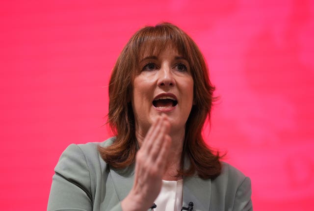 Chancellor Rachel Reeves gives a speech against a red backdrop