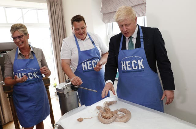 Boris Johnson makes sausages during a visit to Heck Foods