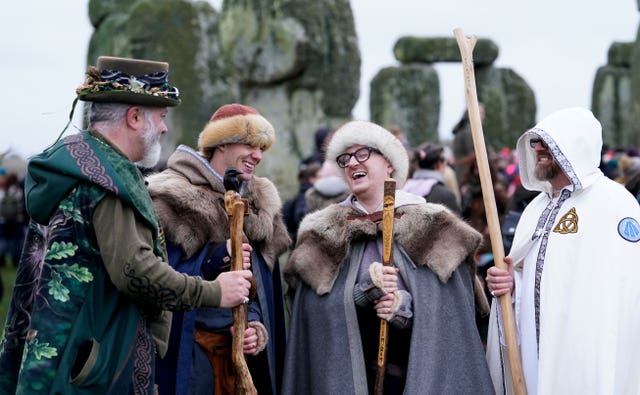 People take part in the winter solstice celebrations during sunrise at the Stonehenge prehistoric monument on Salisbury Plain in Wiltshire