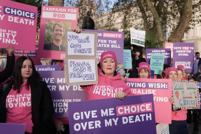 Supporters of the assisted dying bill holding signs that read 'give me choice over my death'