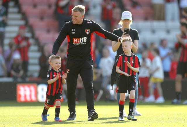 Bournemouth manager Eddie Howe celebrates on the pitch with his sons Harry and Rocky