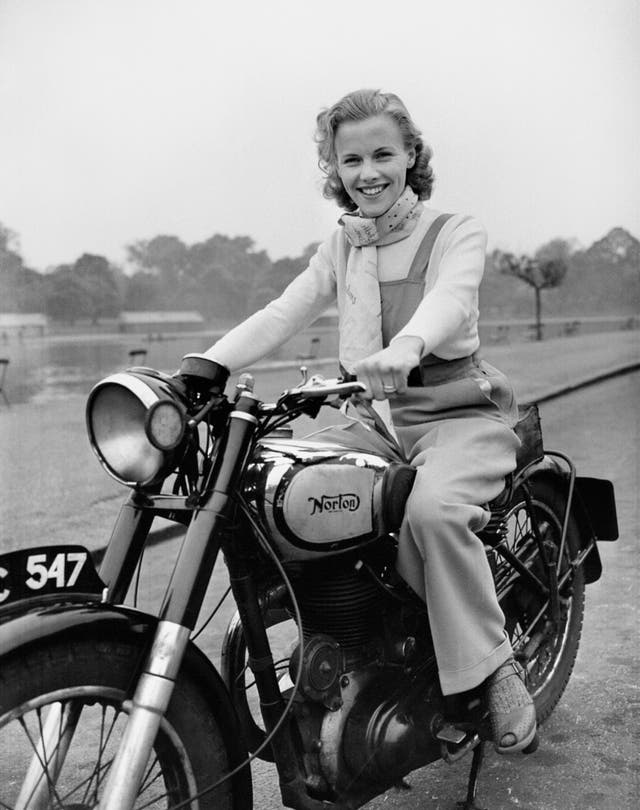 Honor Blackman pictured riding her Norton Big Four motorcycle through Hyde Park in London at age 23 in 1949 (PA)