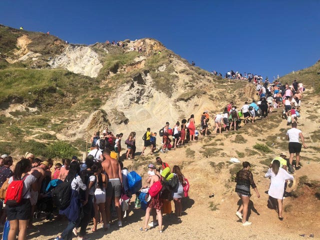 Members of the public leaving the beach after air ambulances landed on Saturday (Dorset Police/PA)