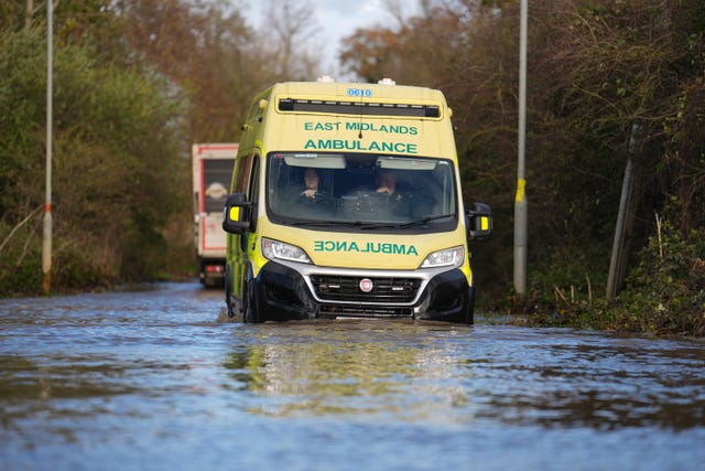 An ambulance driving through floodwater