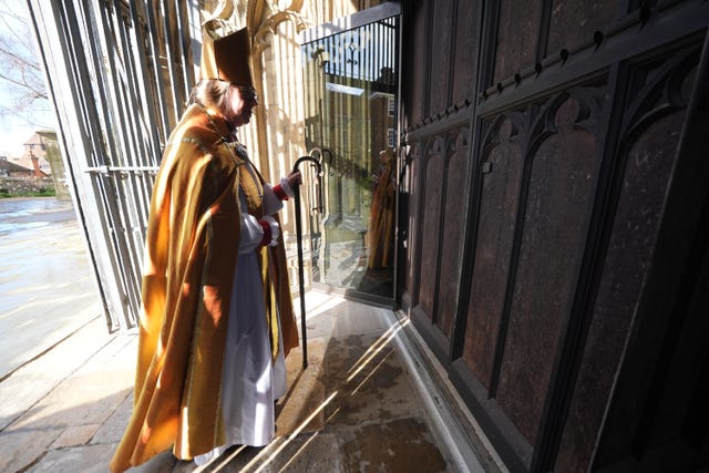 Dame Sarah strikes the west door of Canterbury Cathedral 
