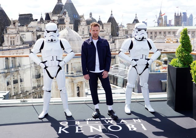 Ewan McGregor poses with stormtrooper extras at a photocall
