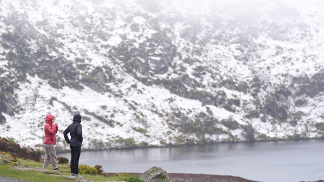 People looking at the snow at Lough Bray Upper on Powerscourt Mountain in Co Wicklow in April (
