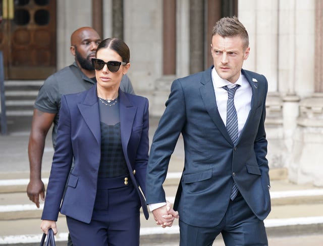 Rebekah and Jamie Vardy holding hands as they leave the Royal Courts Of Justice