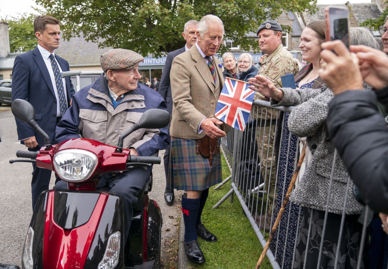 King wears new tartan and greets wellwishers in French on village
