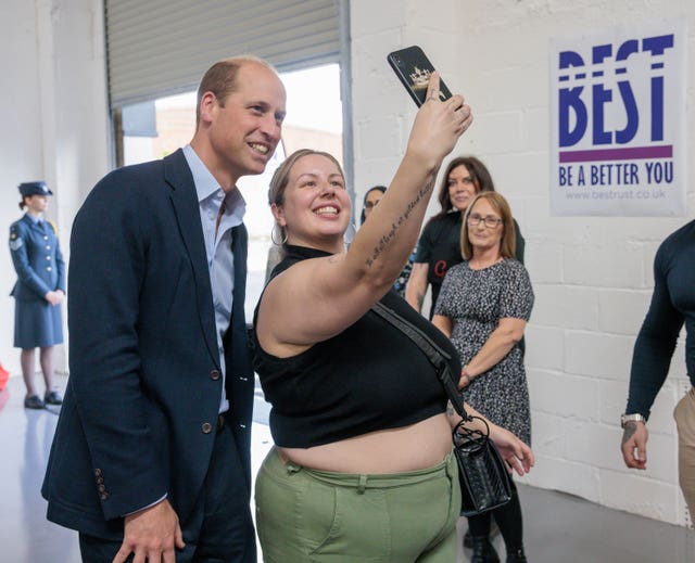 The Prince of Wales poses for a selfie with a volunteer